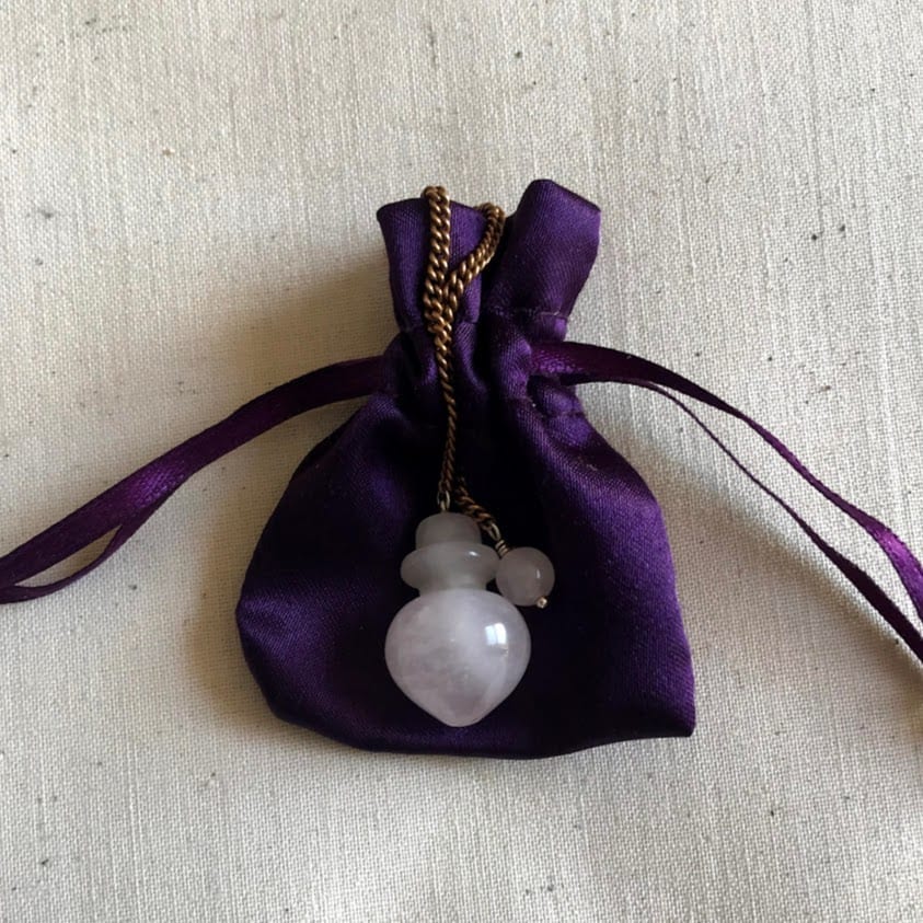 rose quartz pendulum on purple bag