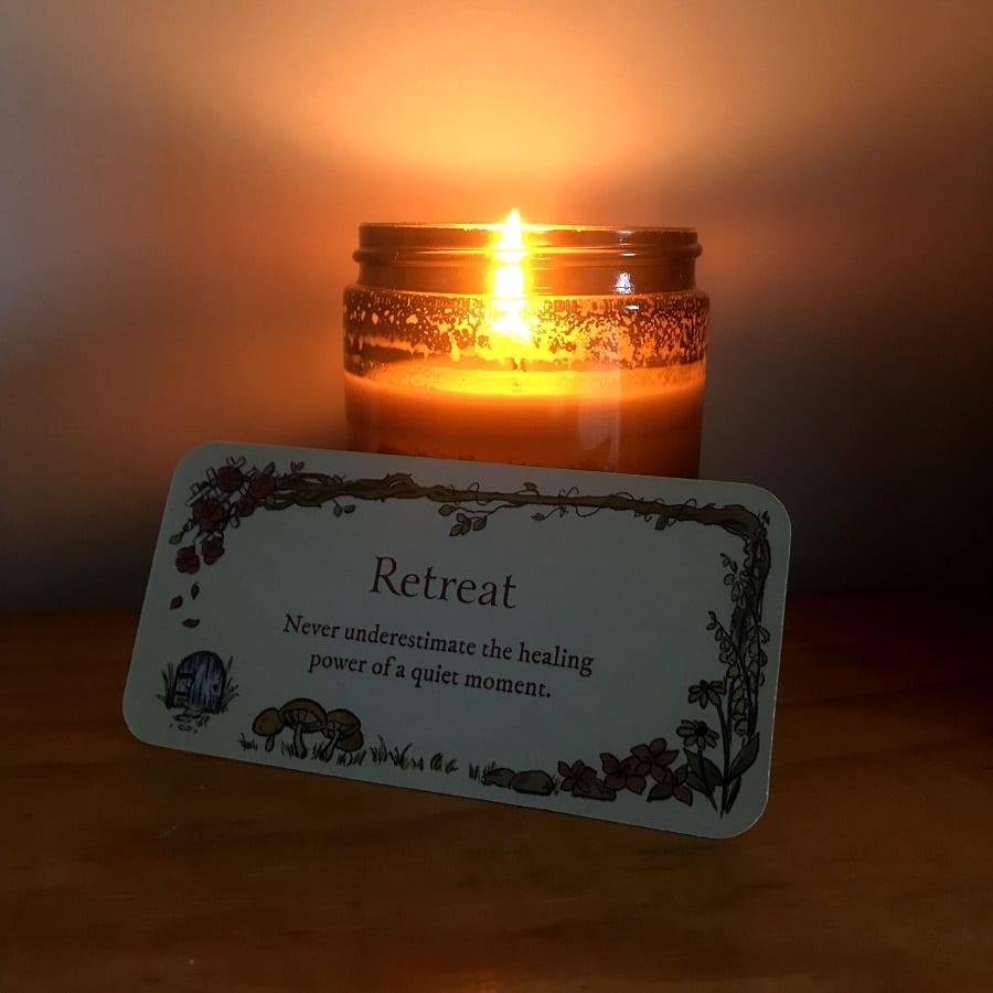 lit candle and a card that says "retreat"