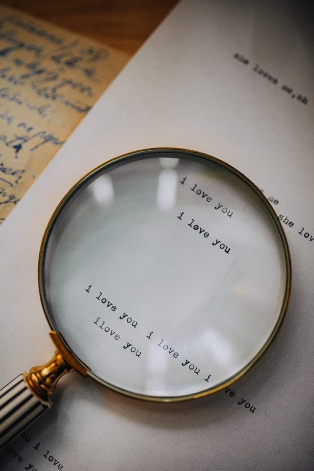 magnifying glass and paper that says "I love you" on it