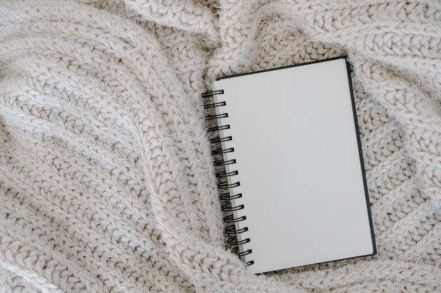 blank notebook on a white blanket